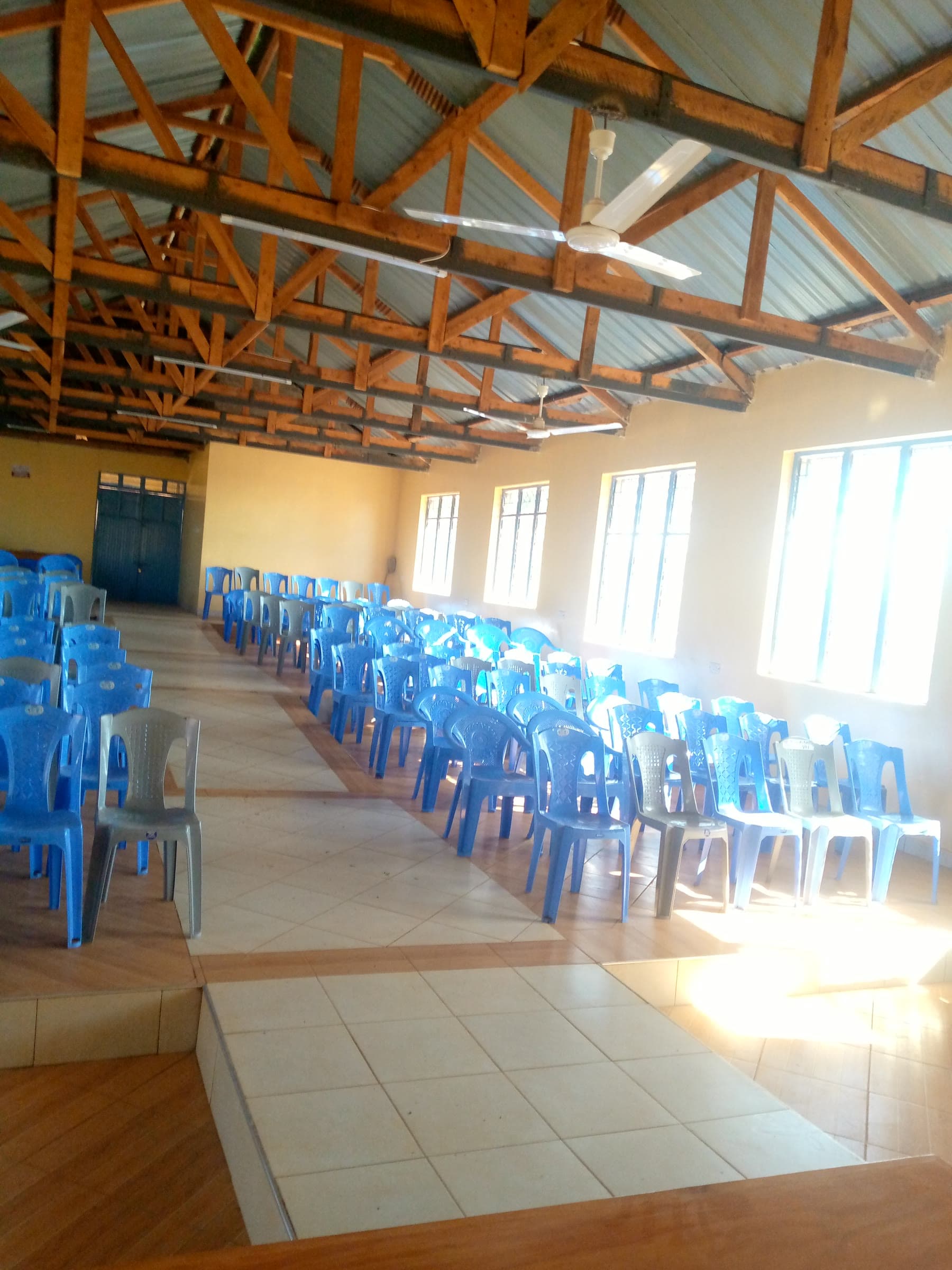 Rows of chairs set side by side under the timber roof